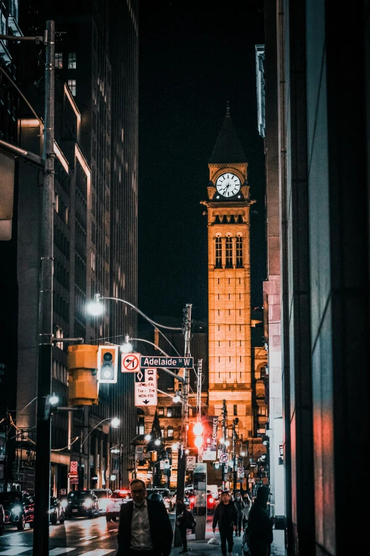 the people are walking down the street in the city at night