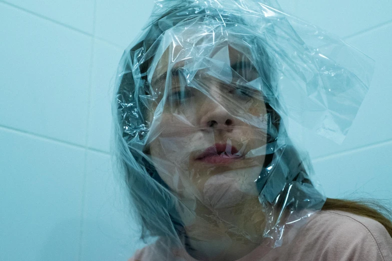 the girl's reflection is visible through the clear plastic covering her face