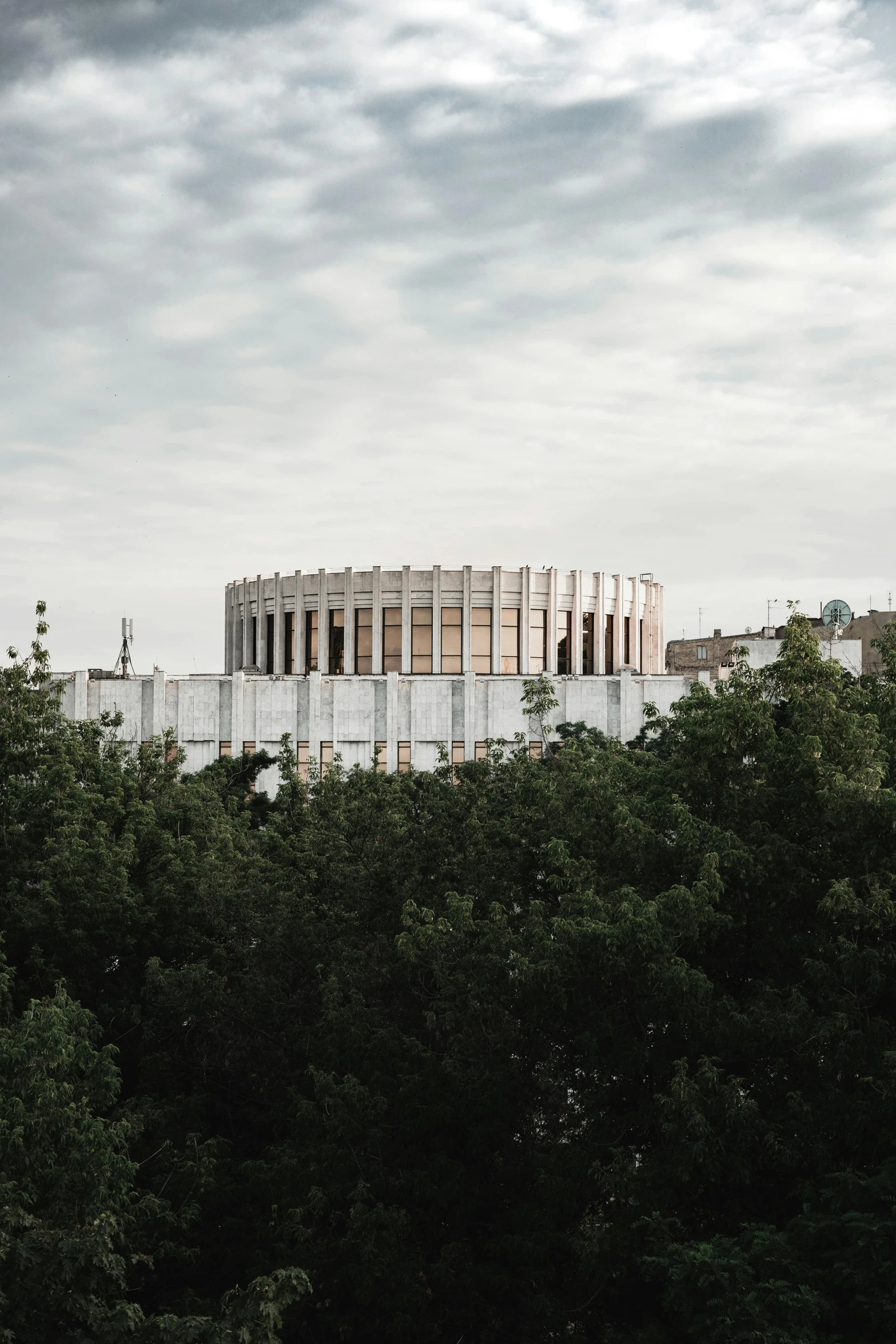 a building sitting on the side of a hill surrounded by trees