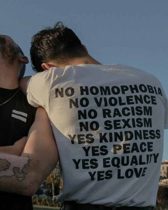 two men with tattoos kissing under the same sky