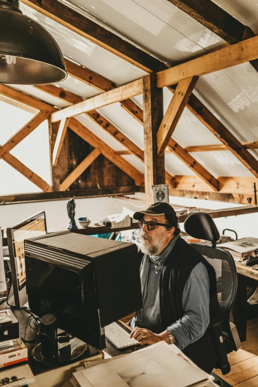 a man working at a desk with computer equipment