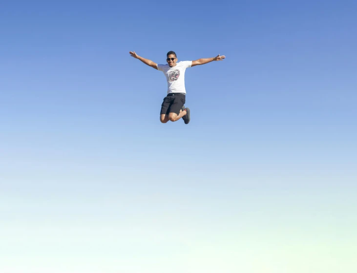 the young man is jumping high in the sky