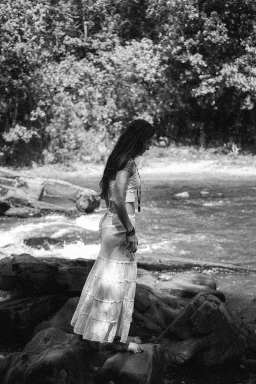 a black and white po of a woman walking on rocks