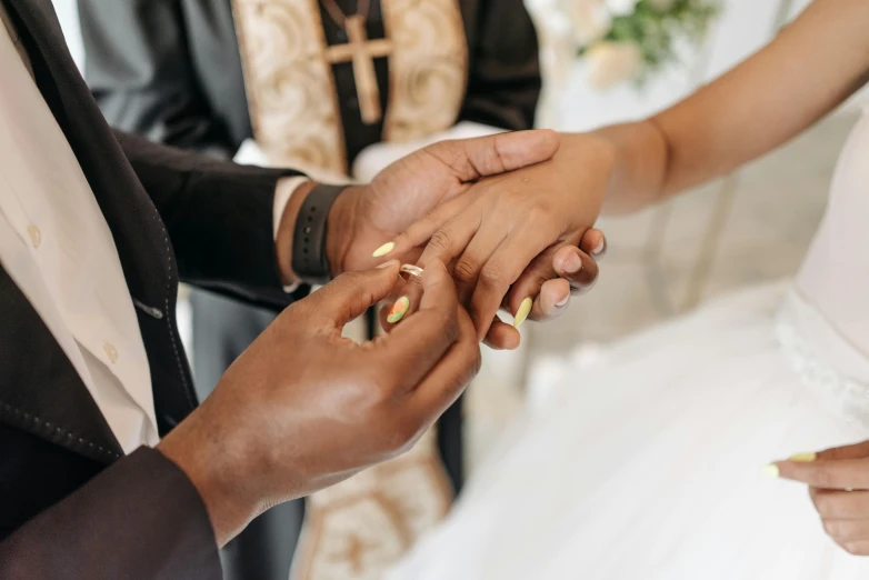 a close up view of a bride and groom exchanging their wedding rings