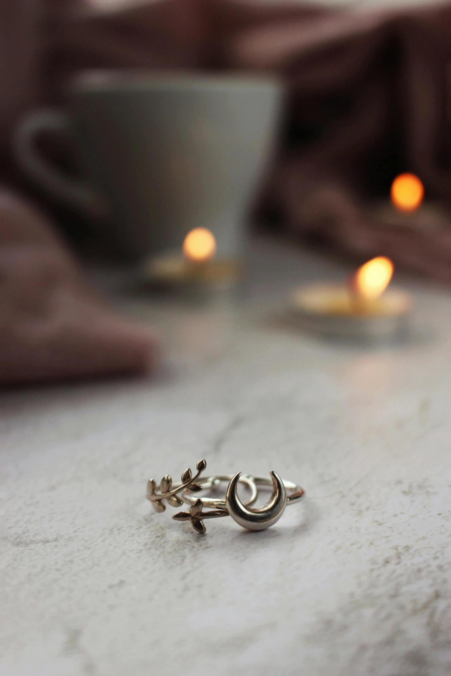 two rings on top of a table near a coffee mug