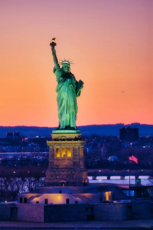 a view of the statue of liberty at sunset