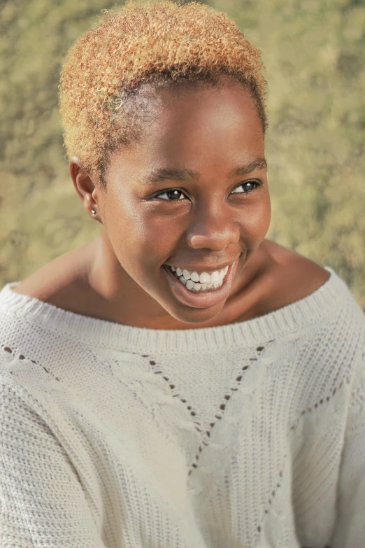 the smiling woman is wearing a sweater and posing for a picture