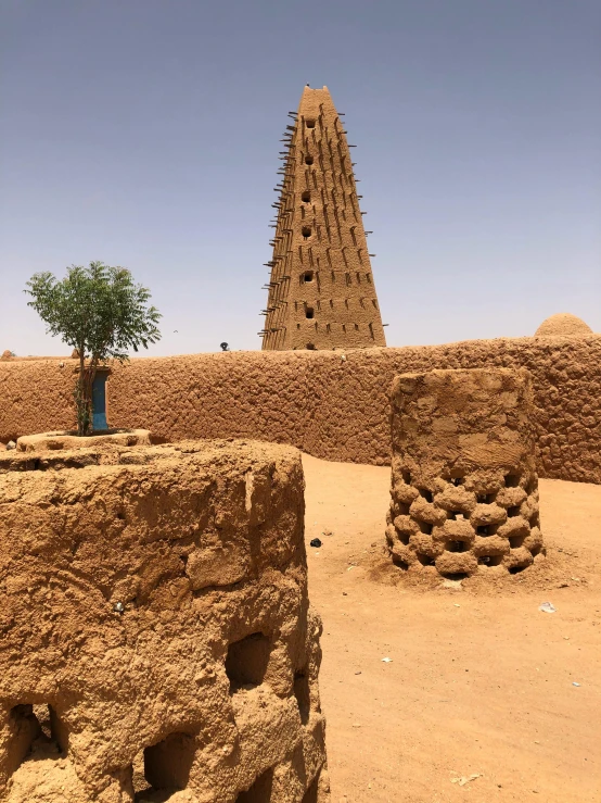 large structures in the desert with one tree growing from them