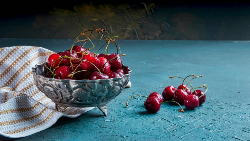 a bowl full of cherries sitting on a table