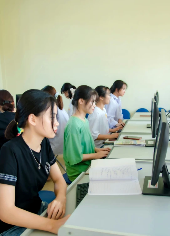 a group of students at desks with paper and a laptop