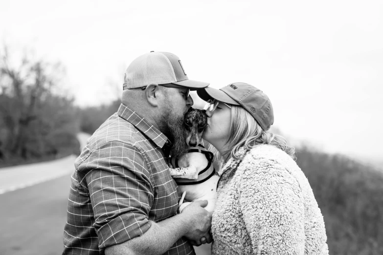 a man and woman kiss on the cheek of each other while a car approaches them