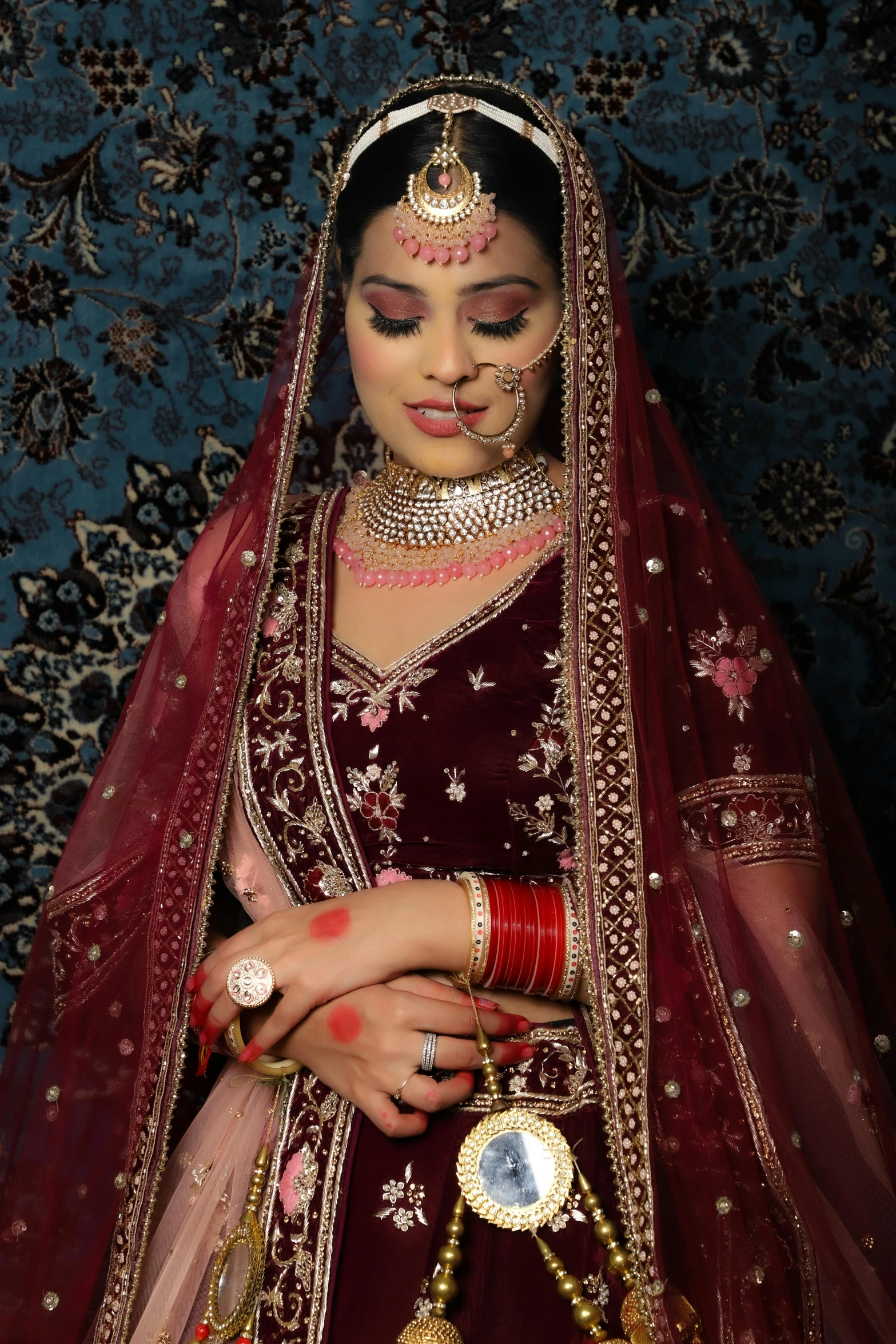 an indian bride wearing jewelry poses for a po