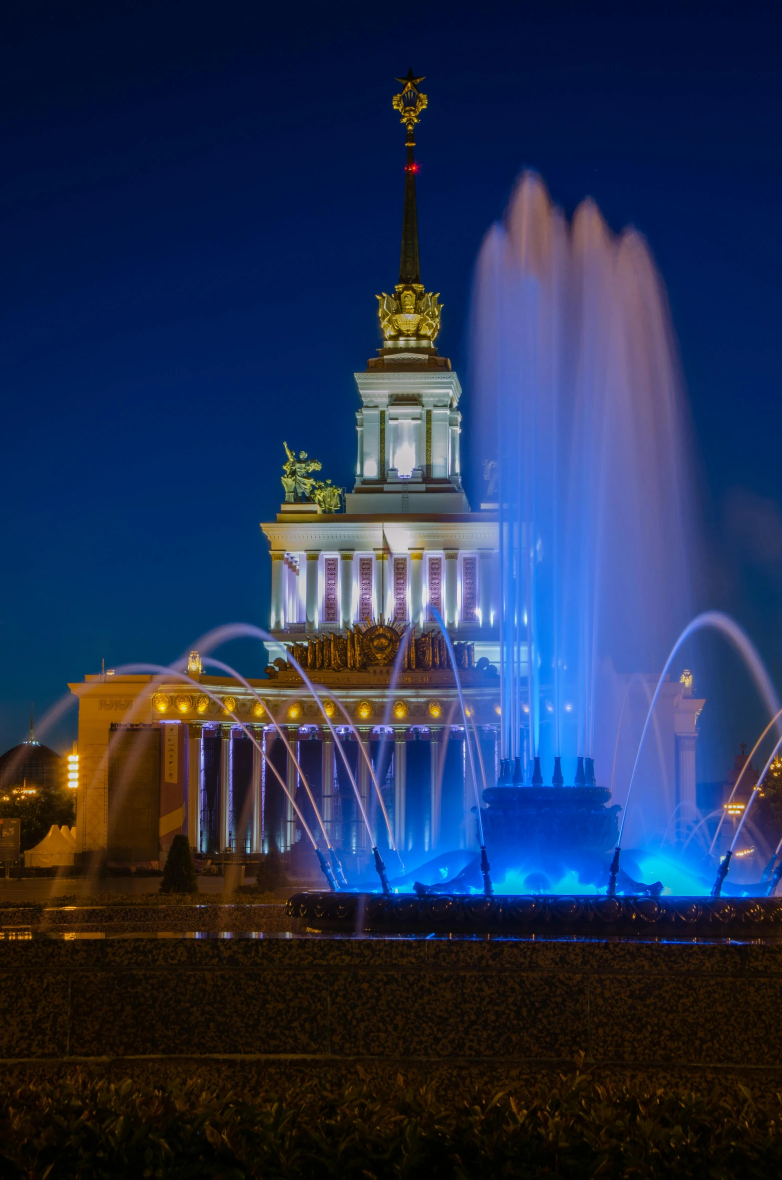 illuminated fountains in front of a stately building at night