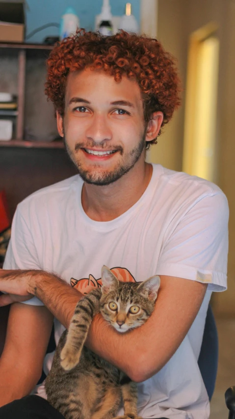 a man that is holding a cat in his lap