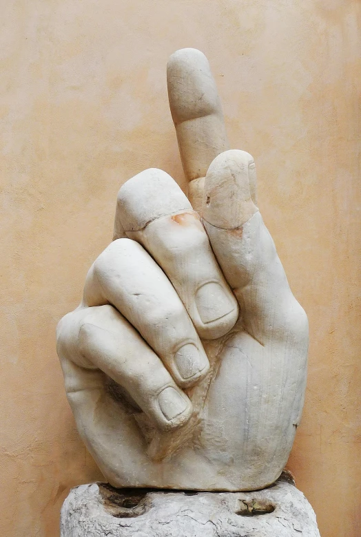 a statue of a hand pointing with a sign pointing down