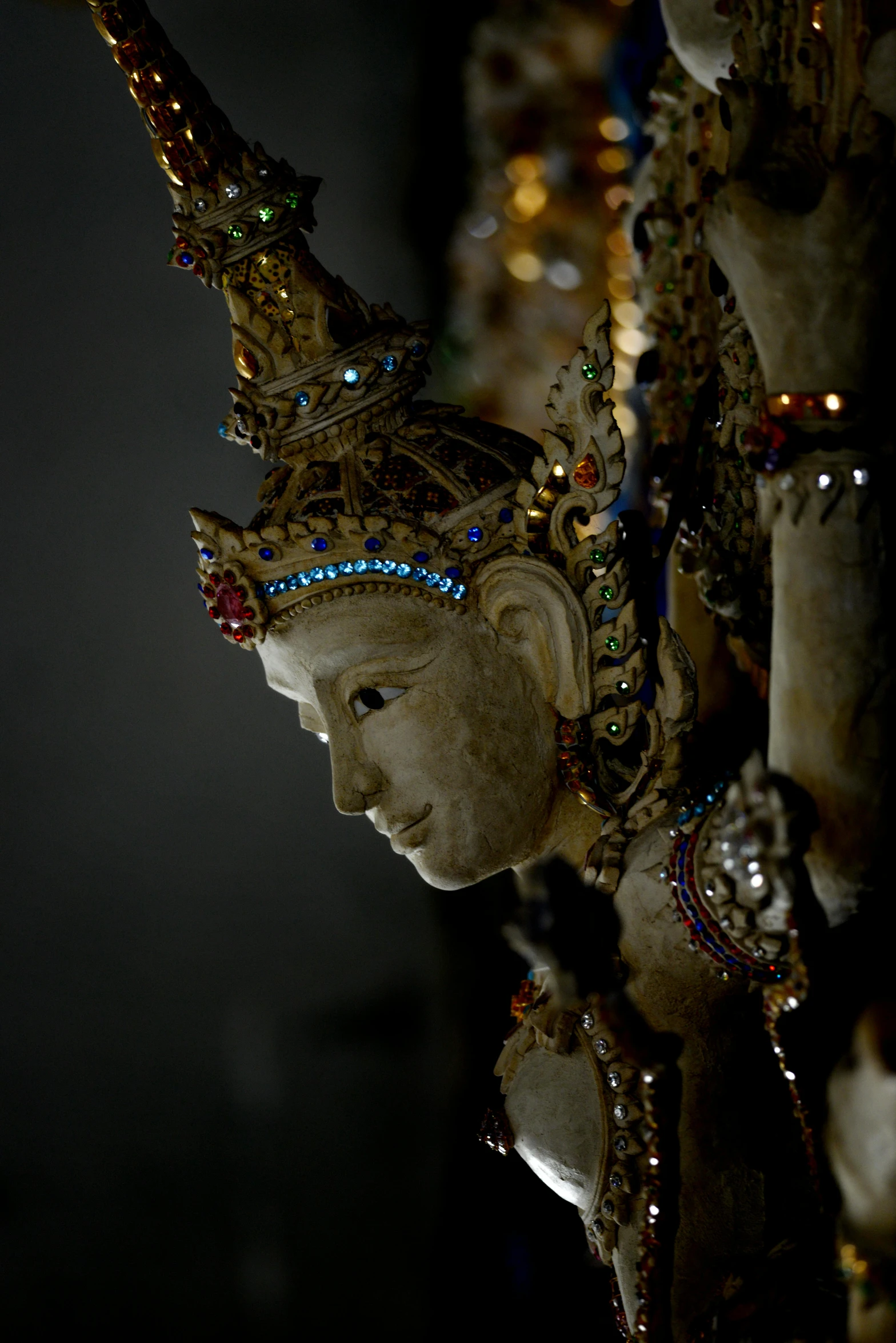 a statue of a girl with golden hair and headdress is lighted by lights