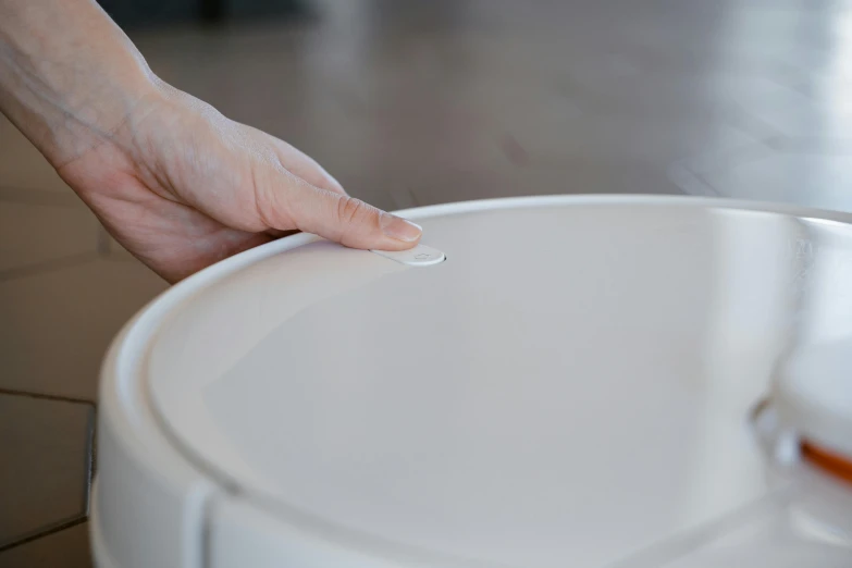 a person that is using a container to place soing on a saucer