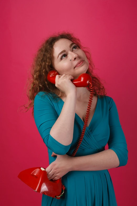 a woman is holding her head down with the phone up to her ear