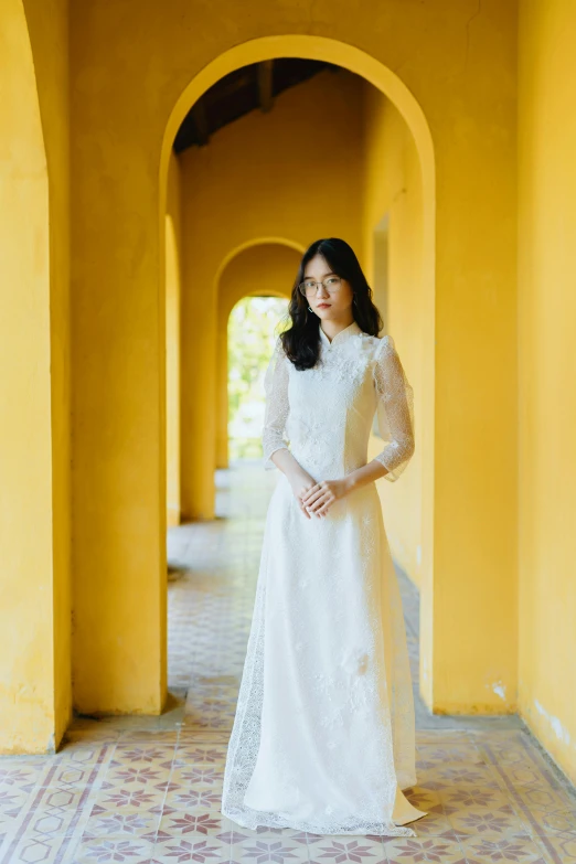 a woman posing for a po while wearing a wedding dress