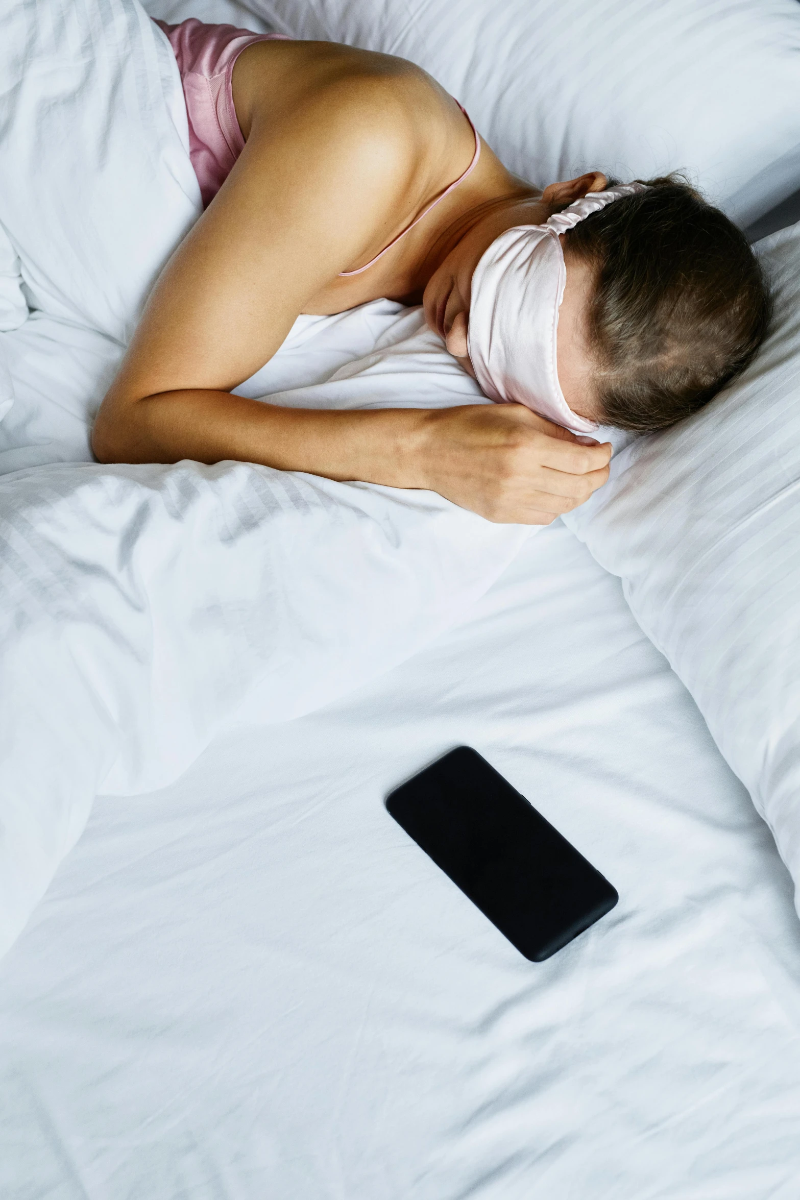 a woman sleeping on her back while holding a cell phone