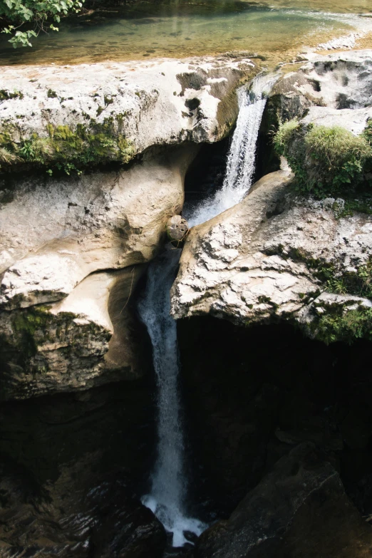 there is a waterfall in the middle of the rocks