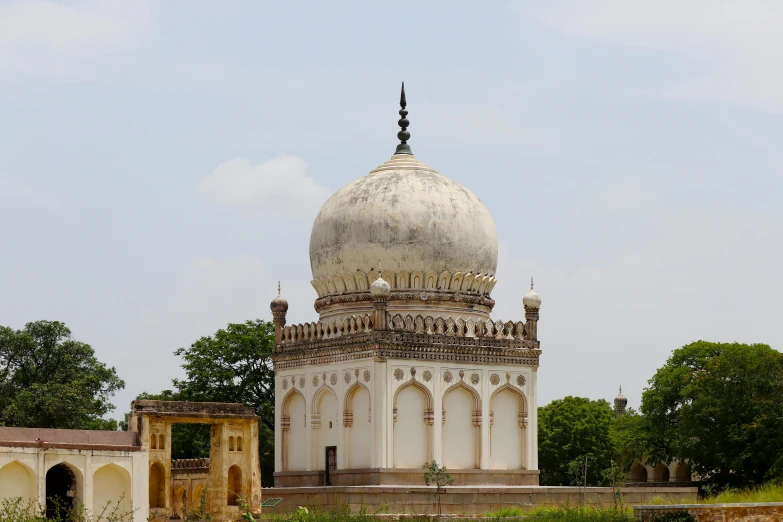 a large building with domes and pillars near many trees