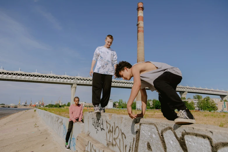 two skateboarders performing tricks while another watches