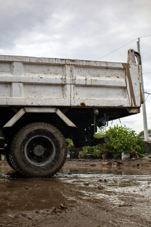 the side of a rusty dump truck on dirt