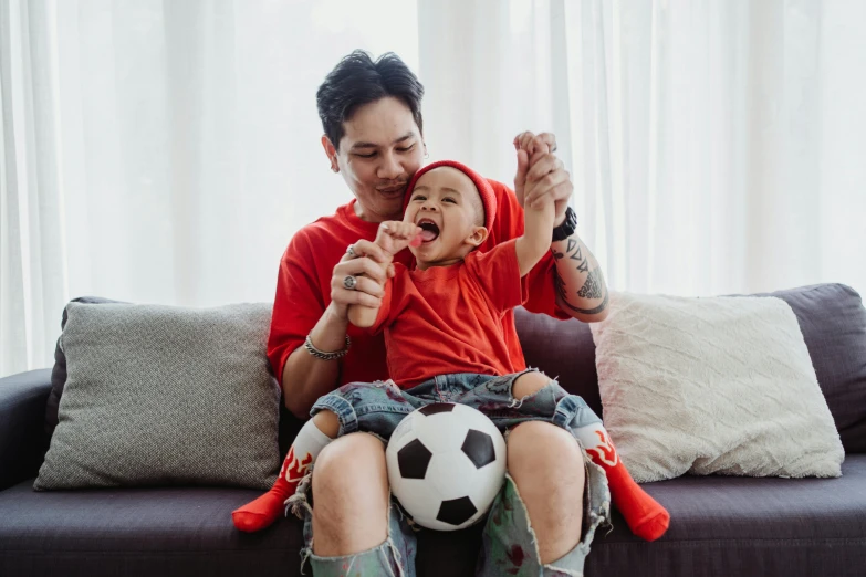 the man and boy are playing with a soccer ball