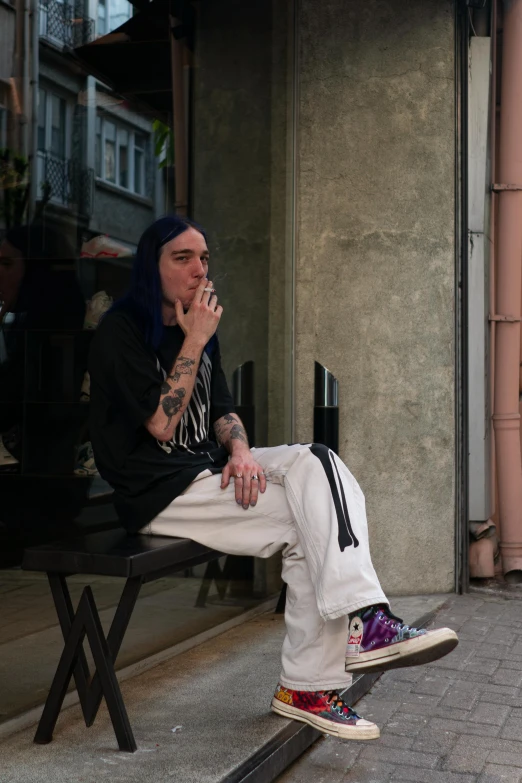 a man with tattoos sitting on a bench