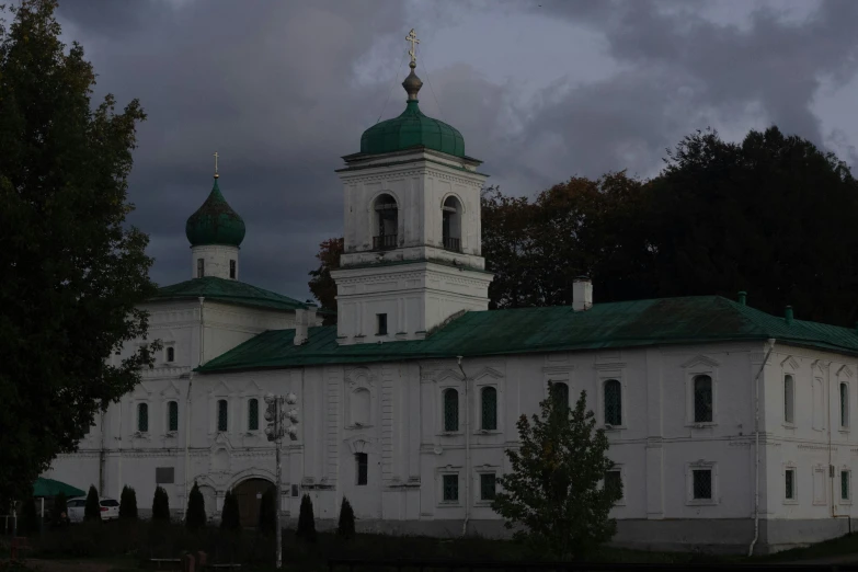 a white building with three towers on a cloudy day