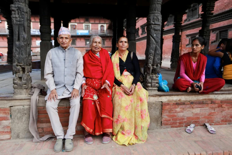 a group of people sit next to each other in front of some pillars