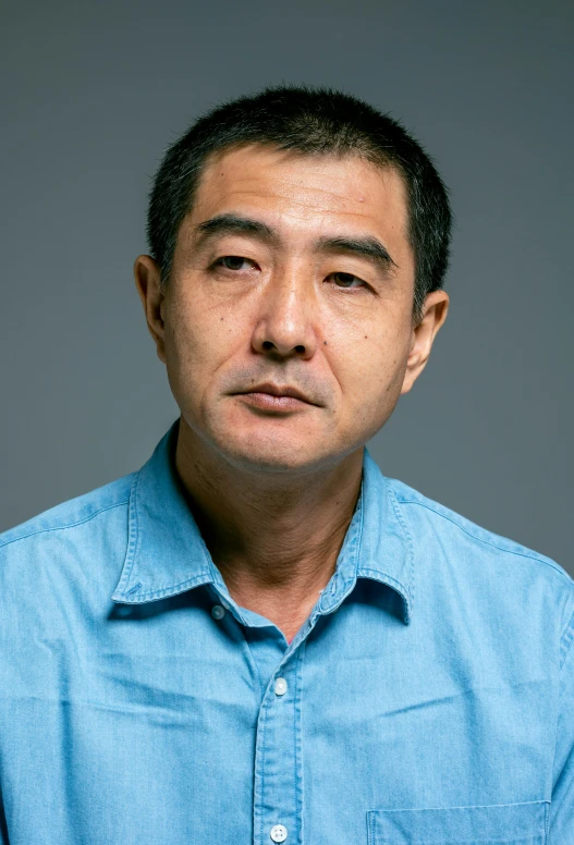 a man in a blue shirt is posing for a picture