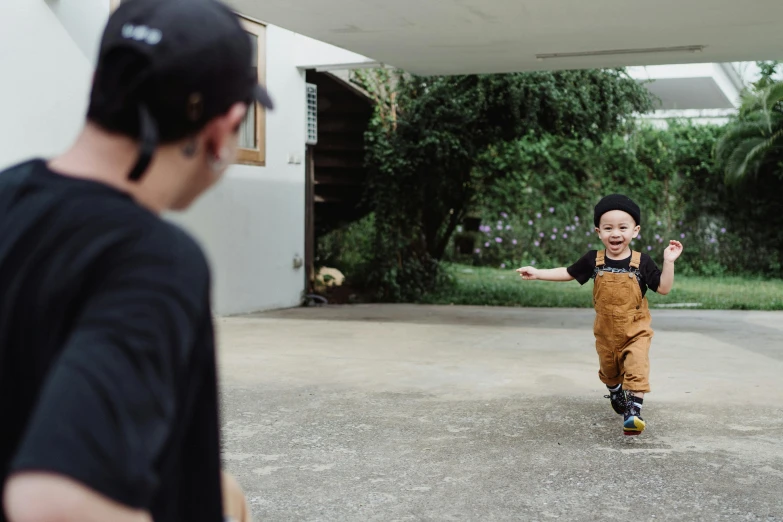 a boy standing next to an older man in a driveway