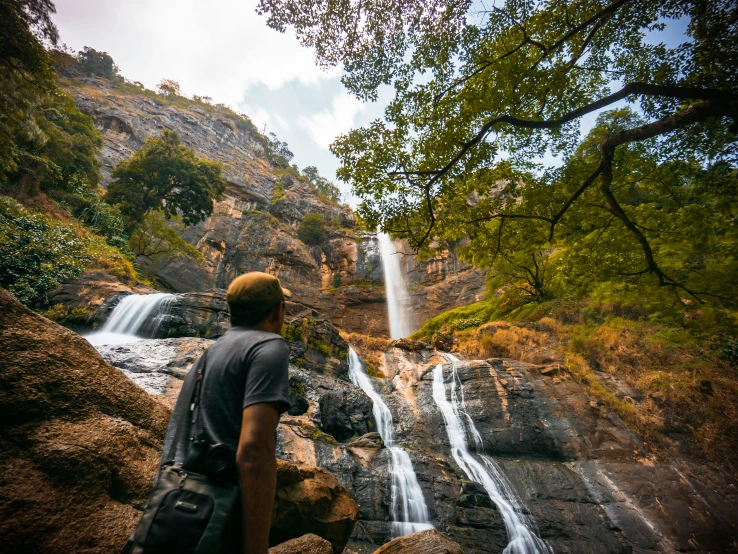 a man is standing next to a waterfall