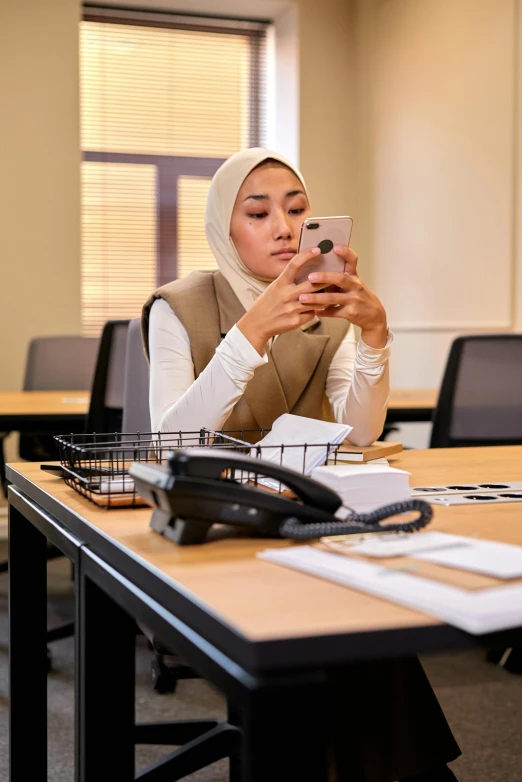 a woman in white head scarf checking her cell phone