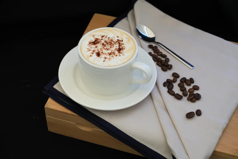 a cappuccino on a saucer with coffee beans