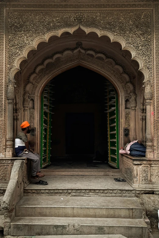 this is a man sitting on steps outside of an ancient building