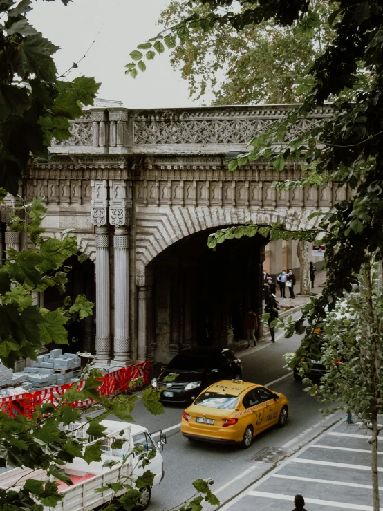 there is a yellow car going under a bridge