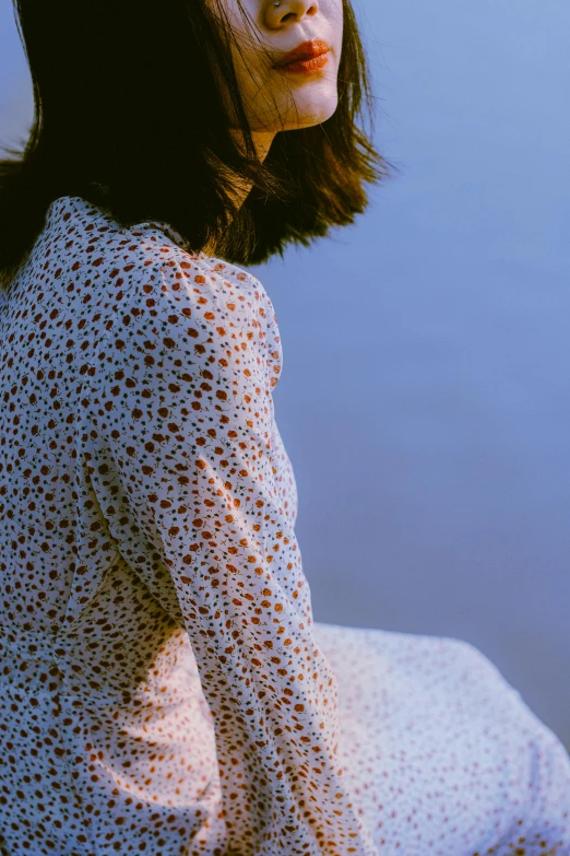 a woman with a black and white outfit looks off to the side