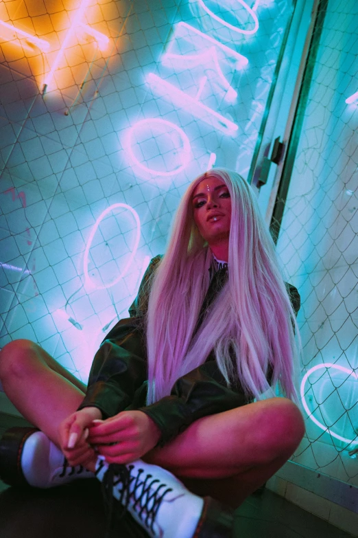 a woman with pink hair sitting on a tiled floor