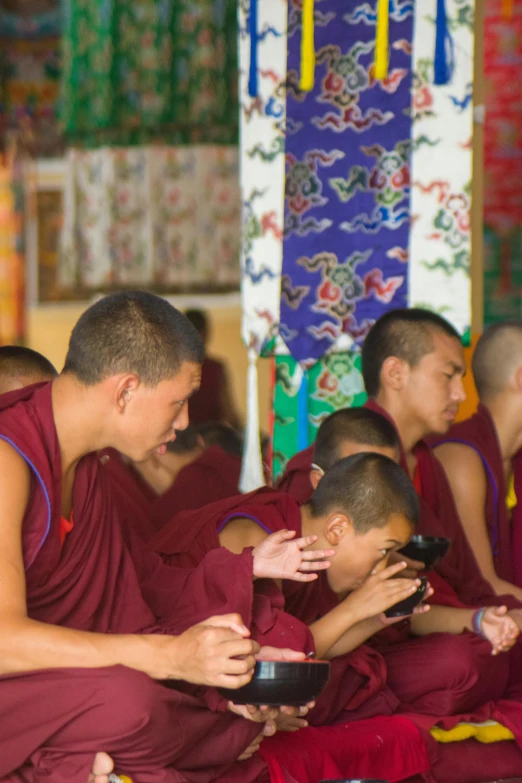 some men are sitting together in buddhist robes