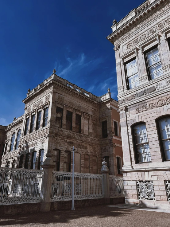 a tall brown building with lots of windows and a fence