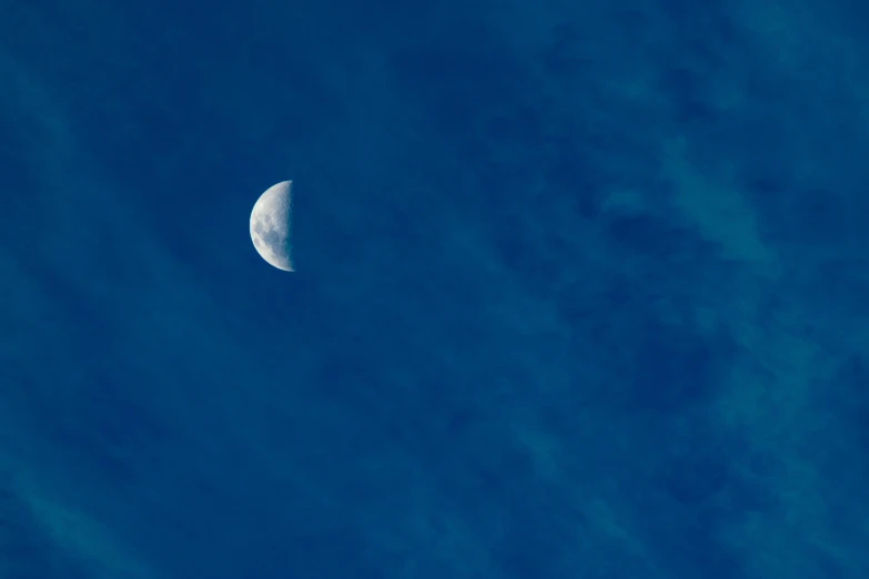 an half moon on a clear blue sky