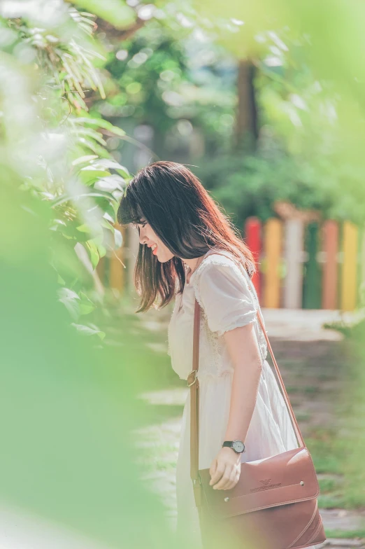 a woman is carrying a brown bag with her back pocket