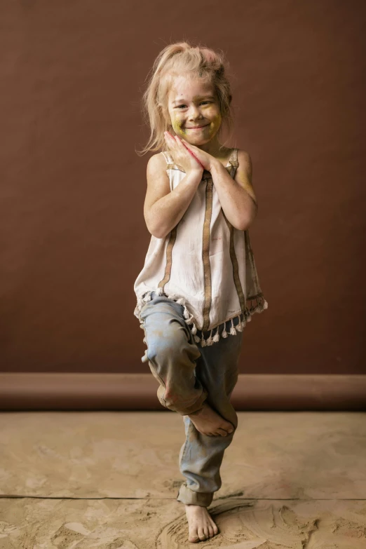 a smiling little girl is standing on her feet