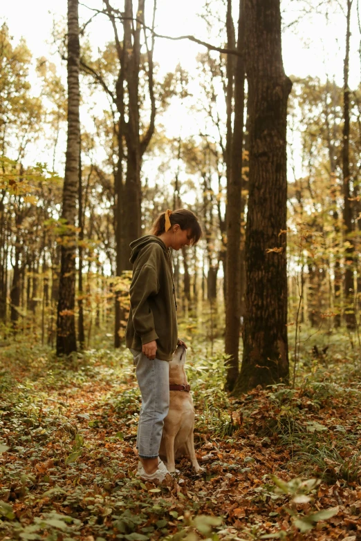 a man and his dog standing in the woods