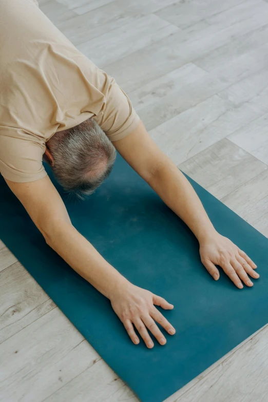 an older woman lying on the floor with a large hand on her head