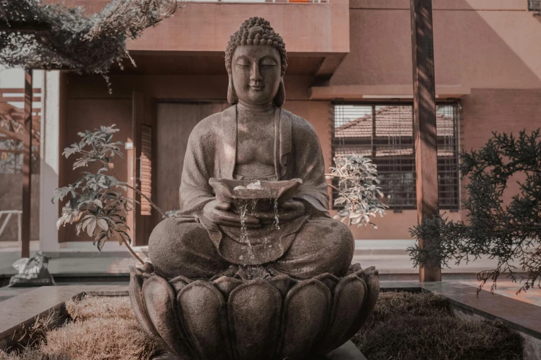 a buddha statue sitting in front of a building