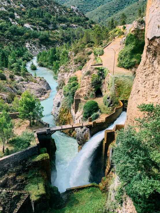 the river is running through a valley with trees